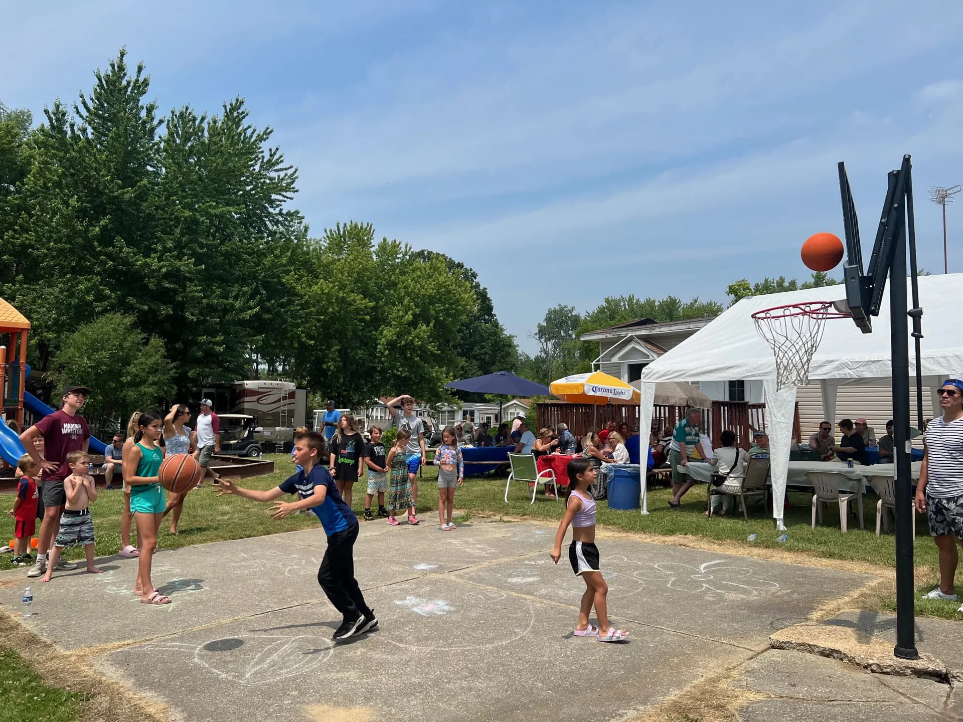 Kids shooting hoops at the campground basketball court