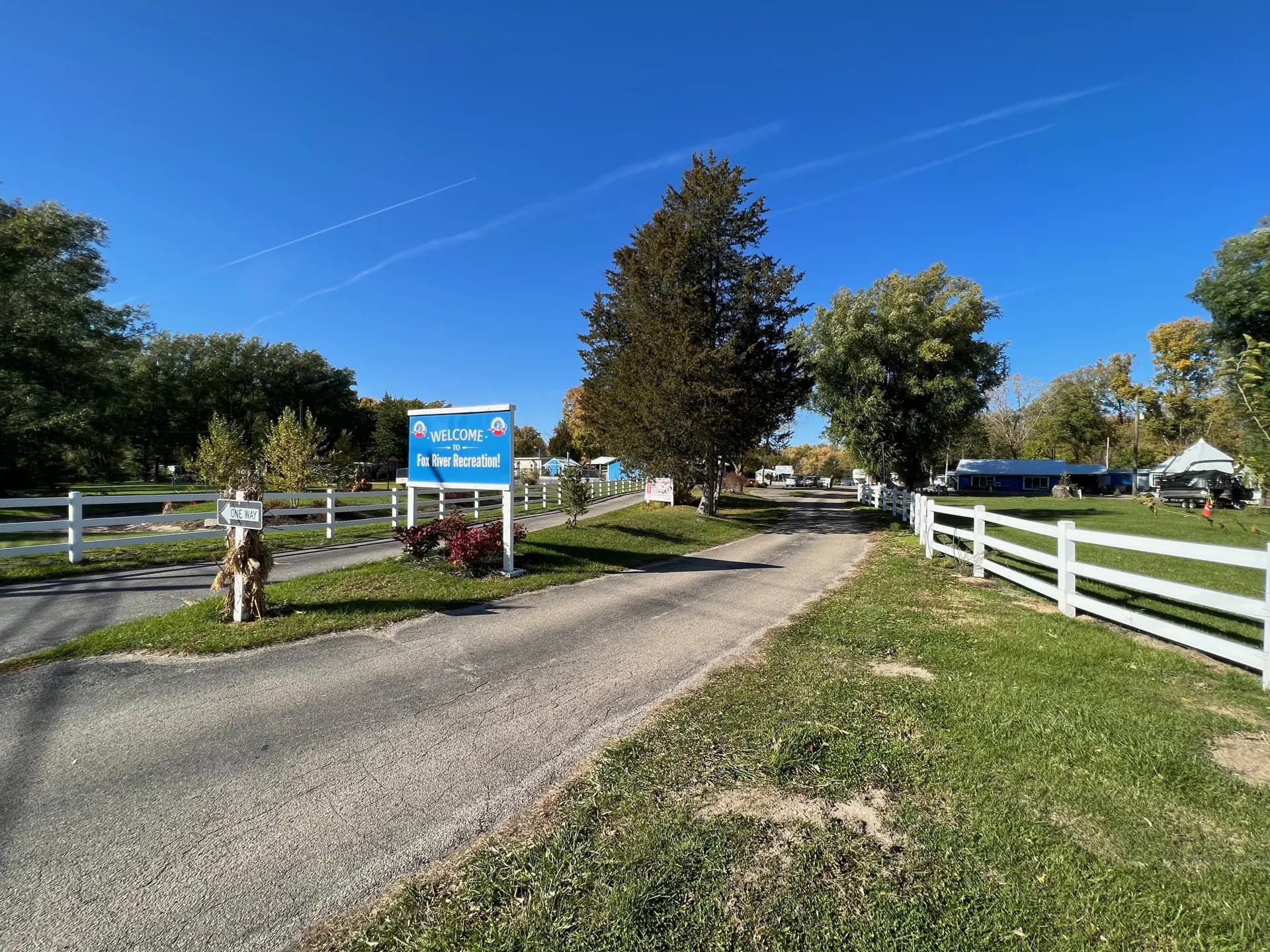 The tree-lined entrance drive and welcome sign at Fox River Recreation