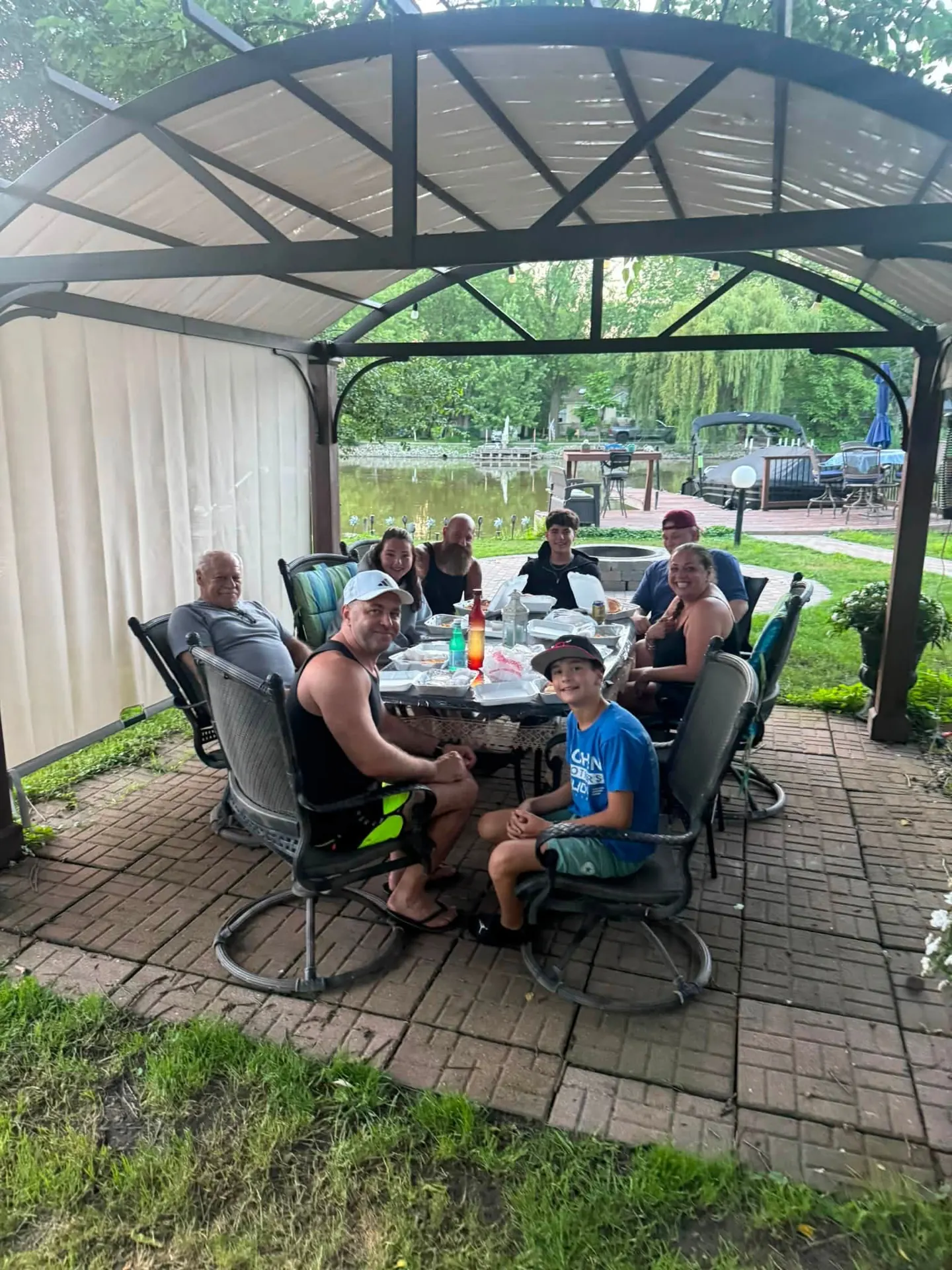 Friends sharing dinner under a gazebo by the water