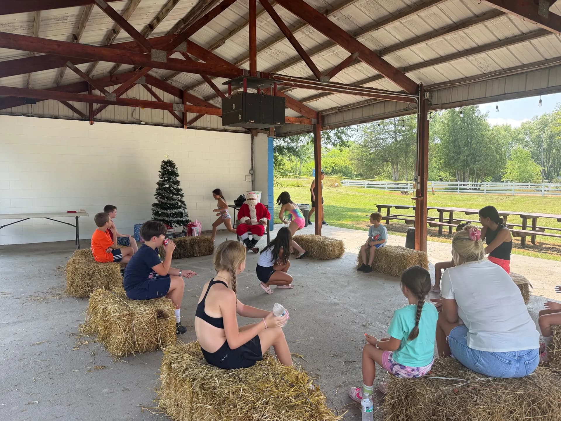 Kids on hay bales at a holiday party in the pavilion