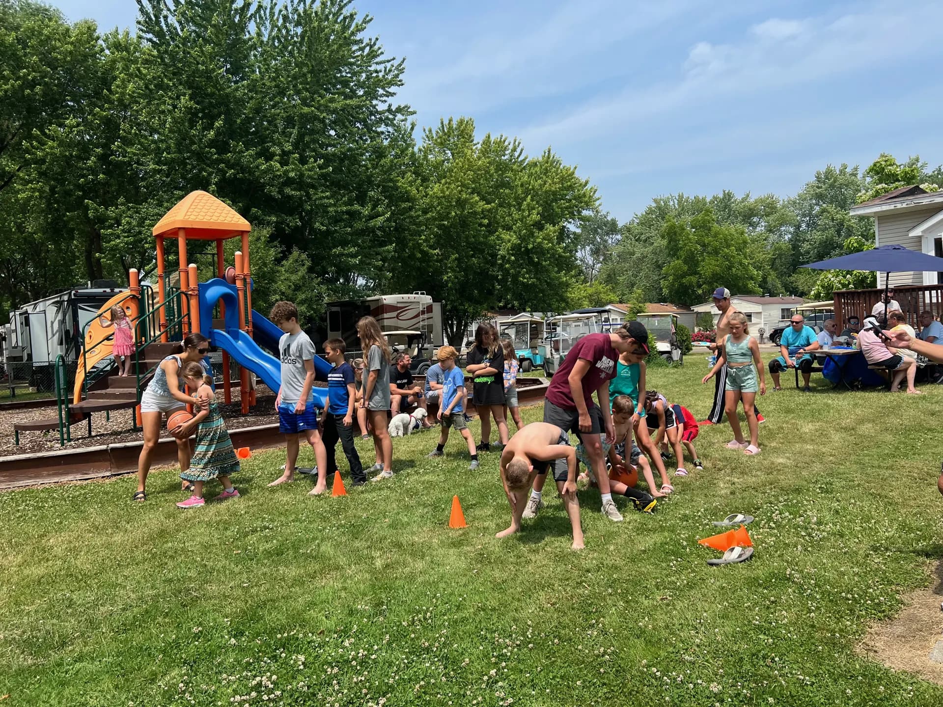 Families playing lawn games by the playground