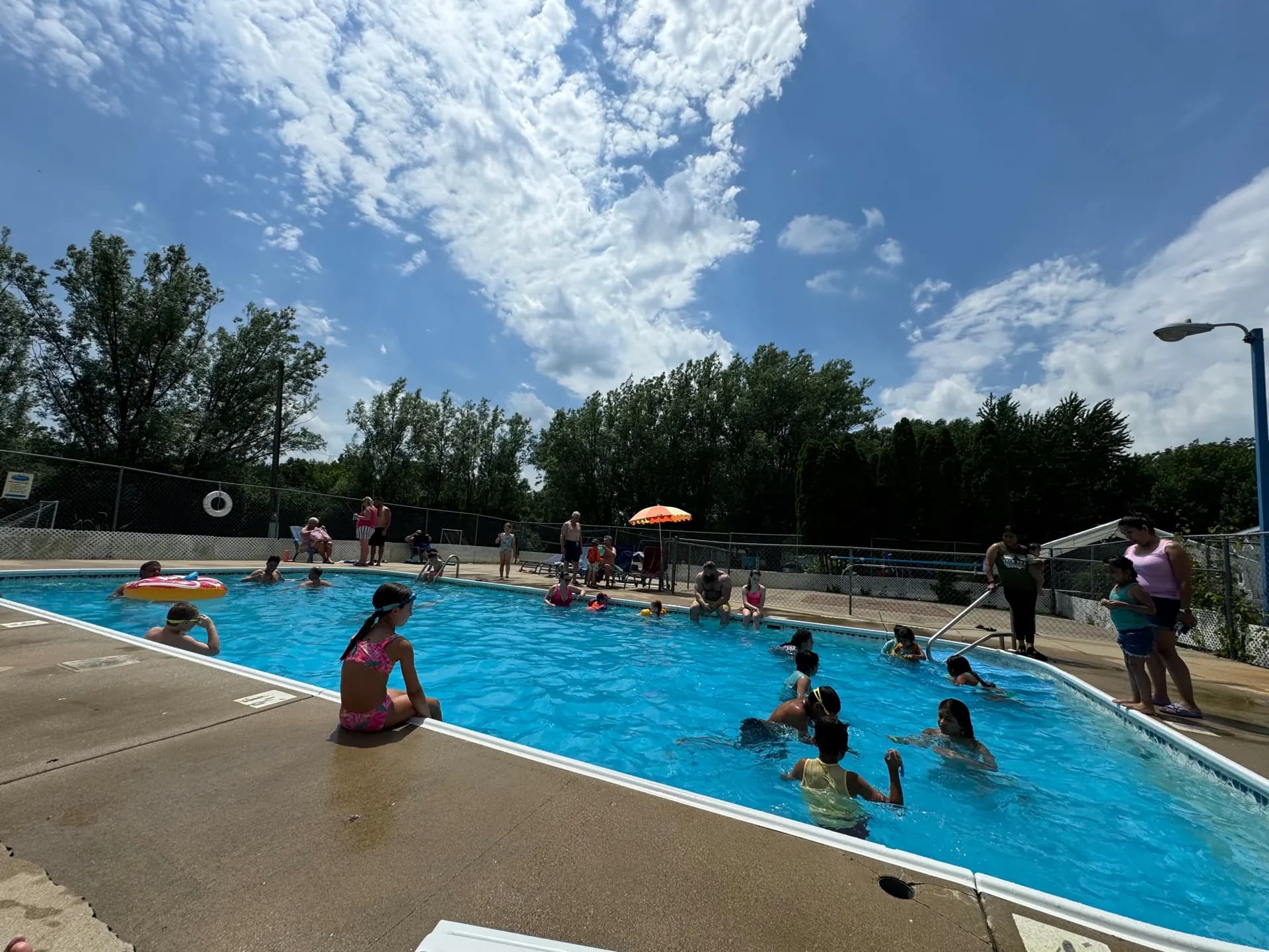Guests swimming in the outdoor pool on a sunny day