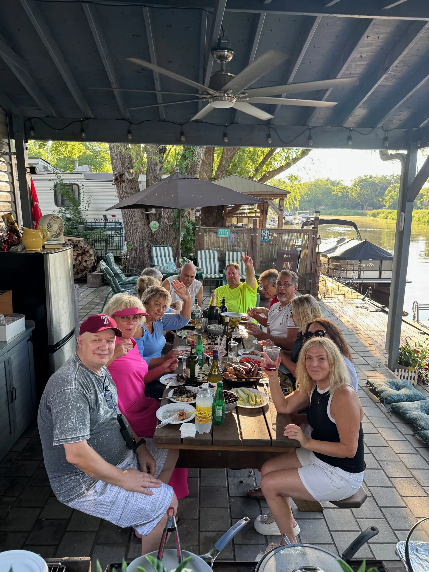 Seasonal campers sharing dinner on a covered riverside patio